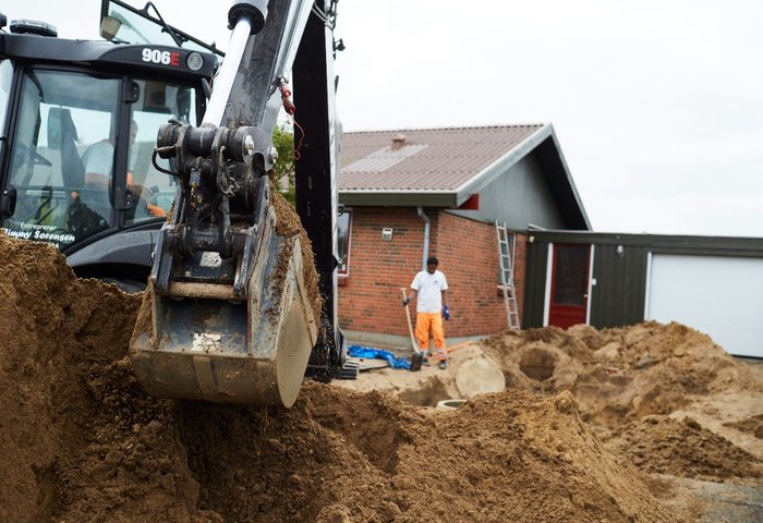 Worker installing septic and sewer pipes in a trench
